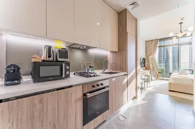 a kitchen with a microwave and a stove top oven at Studio with Dubai Canal View, Walking Distance to Metro Station and Near Downtown Dubai - Peninsula One, Business Bay by Deluxe Holiday Homes in Dubai
