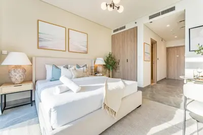 a white bedroom with a white bed and a desk at Studio with Dubai Canal View, Walking Distance to Metro Station and Near Downtown Dubai - Peninsula One, Business Bay by Deluxe Holiday Homes in Dubai