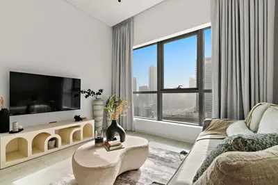 a living room with a couch and a tv at The Smart Concierge - Bay Central in Dubai