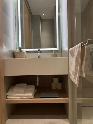 a bathroom with a sink and a mirror and towels at Oakley Square Residence in Dubai
