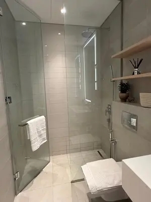 a bathroom with a shower with a glass door at Oakley Square Residence in Dubai