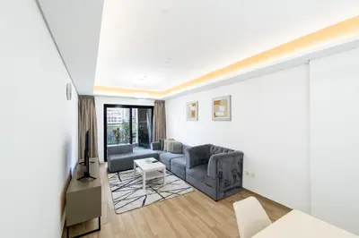 a living room with a couch and a table at Escape24 Elegant 1BR in JVC with Pool View in Dubai