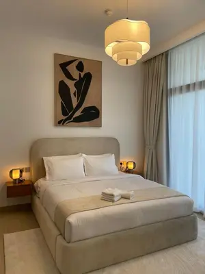 a bedroom with a large bed with a chandelier at Beautiful Brand New Spacious in Dubai