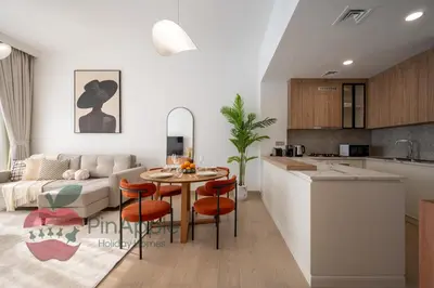 a kitchen and living room with a table and a couch at Beautiful Brand New Spacious in Dubai