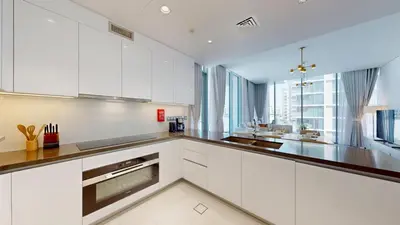 a kitchen with white cabinets and a large window at Vacationer l Serene 3 Bed Haven l Private Beach l District One in Dubai