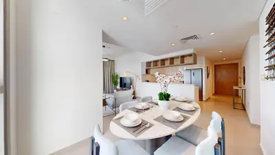 a dining room and living room with a table and chairs at Vacationer I Luxury 3 Bedroom Apartment I Iconic Burj Khalifa View I Heart of Downtown in Dubai