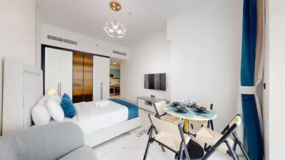 a bedroom with a bed and a table and chairs at Vacationer I Premium Studio I Pool & Gym Access I Near Miracle Garden I Opalz Tower 2 in Dubai