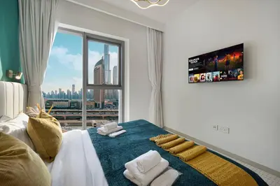 a bedroom with a bed with towels and a window at Luxury 2 bedroom with Burj Khalifa view, connected to Dubai Mall in Dubai