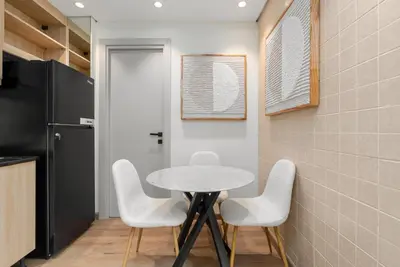 a small kitchen with a table and white chairs at Palmoral Collection Stunning Studio with Dining Area in Dubai