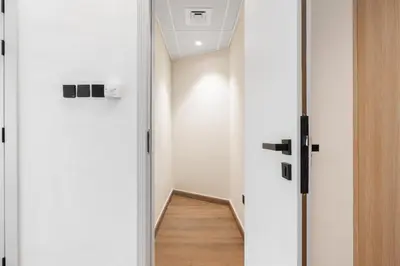 a hallway with white walls and a wooden floor at Palmoral Collection Stunning Studio with Dining Area in Dubai