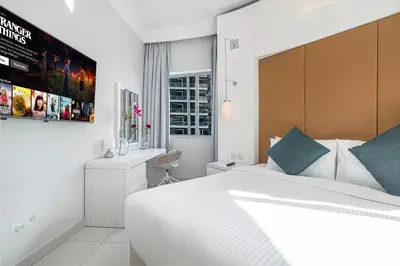 a bedroom with a white bed and a desk at Burj Khalifa view - 2 BR apartment in Downtown in Sabkhah