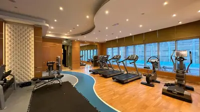 a gym with treadmills and ellipticals in a building at Burj Khalifa view - 2 BR apartment in Downtown in Sabkhah