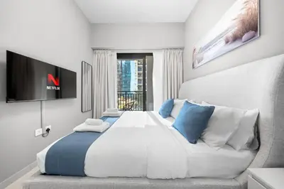 a bedroom with a large white bed with blue pillows at Stylish & Elegant Stay Prime Business Bay Spot in Dubai