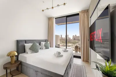 a bedroom with a large bed and a large window at VayK - Gorgeous 1BR Retreat in Binghatti Corner in Dubai