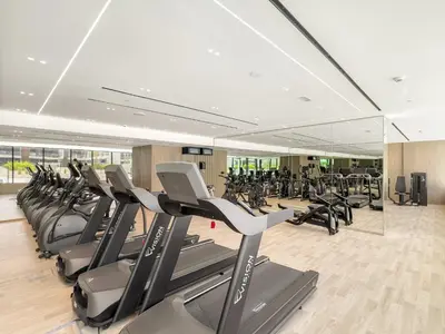 a gym with a lot of treadmills and elliptical machines at VayK - Gorgeous 1BR Retreat in Binghatti Corner in Dubai