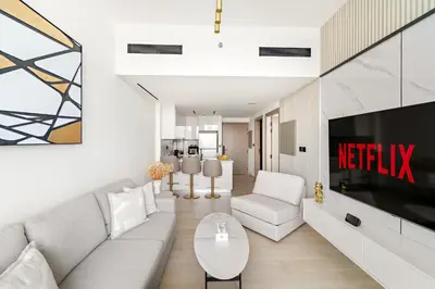 a living room with a couch and a tv at VayK - Gorgeous 1BR Retreat in Binghatti Corner in Dubai