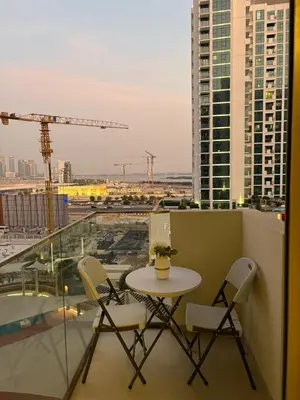 a balcony with a table and chairs on a building at Deluxe studio water front in Dubai