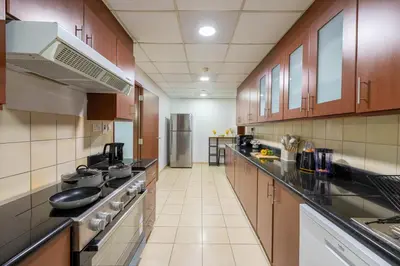 a large kitchen with wooden cabinets and counters at JBR Saddaf 4 By Luxe Living - Marina & Sea Views in Dubai