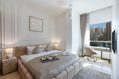 a hotel room with a large bed with a desk at JBR Saddaf 4 By Luxe Living - Marina & Sea Views in Dubai