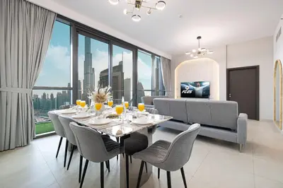 a dining room with a table and chairs with a view at Downtown Views By Luxe Living - Full Burj Khalifa Views in Dubai