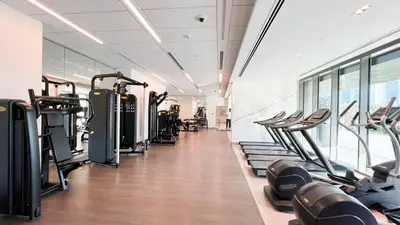 a gym with rows of treadmills and machines at Downtown Views By Luxe Living - Full Burj Khalifa Views in Dubai