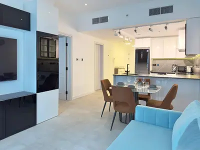 a kitchen and living room with a table and chairs at Modern & Cozy 1BR Apartment | Dubai Eye View in Dubai