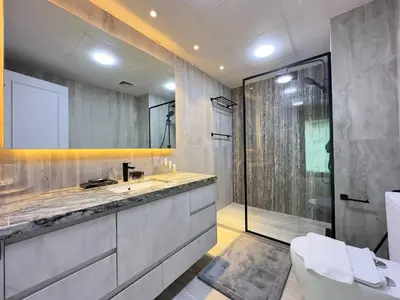 a bathroom with two sinks and a glass shower at Modern & Cozy 1BR Apartment | Dubai Eye View in Dubai