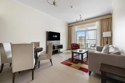 a living room with a couch and a table at Serene 1BR with Balcony & Pool in Siraj Tower in Dubai