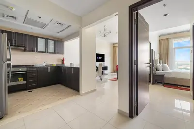 a kitchen with a large open door to a bedroom at Serene 1BR with Balcony & Pool in Siraj Tower in Dubai