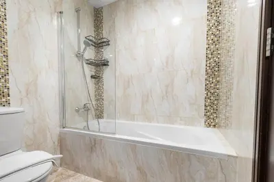 a bathroom with a shower and a toilet at Serene 1BR with Balcony & Pool in Siraj Tower in Dubai