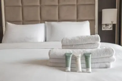 a pile of towels sitting on top of a bed at Serene 1BR with Balcony & Pool in Siraj Tower in Dubai