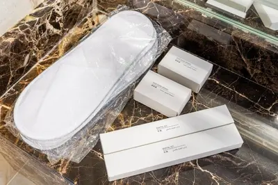 a white toilet and two white boxes on a counter at Serene 1BR with Balcony & Pool in Siraj Tower in Dubai