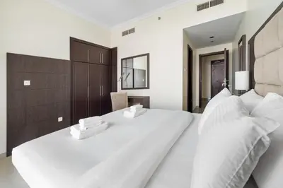 a bedroom with a large white bed with two pillows at Serene 1BR with Balcony & Pool in Siraj Tower in Dubai