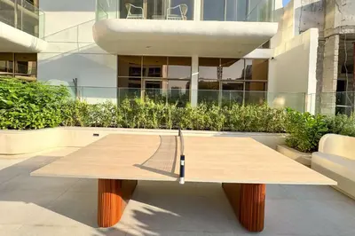 a wooden table sitting in front of a building at PVH - Sleek 1BR near Community Park - Pearl House 1 in Dubai