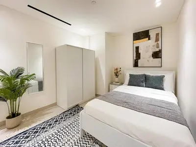 a bedroom with a white bed and a potted plant at Contemporary Luxe Stay at Dawn by Binghatti! in Dubai