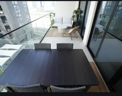 a black table and chairs in a room with windows at Flat in Downtown, Pool & Canal view in Dubai
