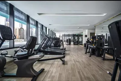 a gym with treadmills and ellipticals in a building at Flat in Downtown, Pool & Canal view in Dubai