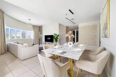 a dining room and living room with a table and chairs at Spacious 3BR with Gym & Pool in Royal Residences in Dubai