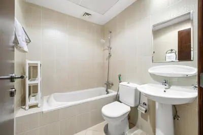 a bathroom with a toilet and a sink and a tub at Spacious 3BR with Gym & Pool in Royal Residences in Dubai
