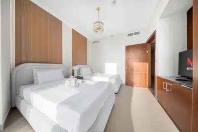 a hotel room with two beds and a television at Luxury 4 BR with full Burj Khalifa and Fountain View - Connected to Dubai Mall and Metro Station in Dubai