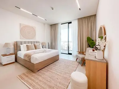 a white bedroom with a large bed and a rug at Amberwood 2BR Haven at Dawn by Binghatti JVC in Dubai