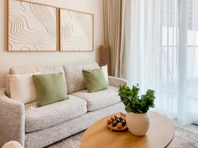 a living room with a couch and a table at Amberwood 2BR Haven at Dawn by Binghatti JVC in Dubai