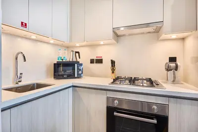 a kitchen with a sink and a stove at STAY BY LATINEM Luxury 1BR Plus Study Holiday Home CB 1808 Near Burj Khalifa in Dubai