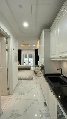 a white kitchen with white cabinets and a sink at Boutique Studio Elegant Stay in Arjan Dubai in Dubai