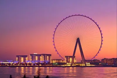 a large ferris wheel in a city at night at Livbnb- 3BR with Maid's Room with Full Ain Dubai View in Dubai