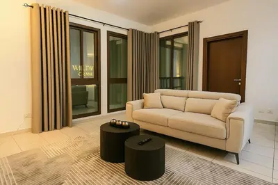 a living room with a couch and a stool at Convenient Location in JVC Bright 1BR with Balcony in Dubai