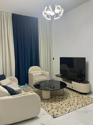 a living room with chairs and a table and a tv at Luxury 2BR in Opal by Danube Private pool in Dubai