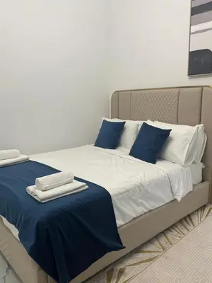 a bed with blue and white sheets and blue pillows at Luxury 2BR in Opal by Danube Private pool in Dubai