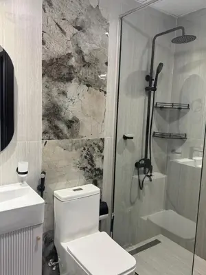 a bathroom with a shower and a toilet and a sink at Luxury 2BR in Opal by Danube Private pool in Dubai