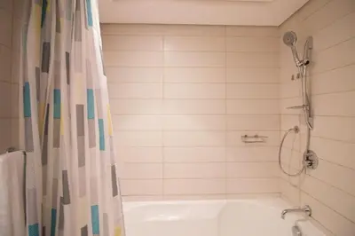 a bathroom with a tub and a shower with a shower curtain at Studio at Burj Views L246 in Dubai